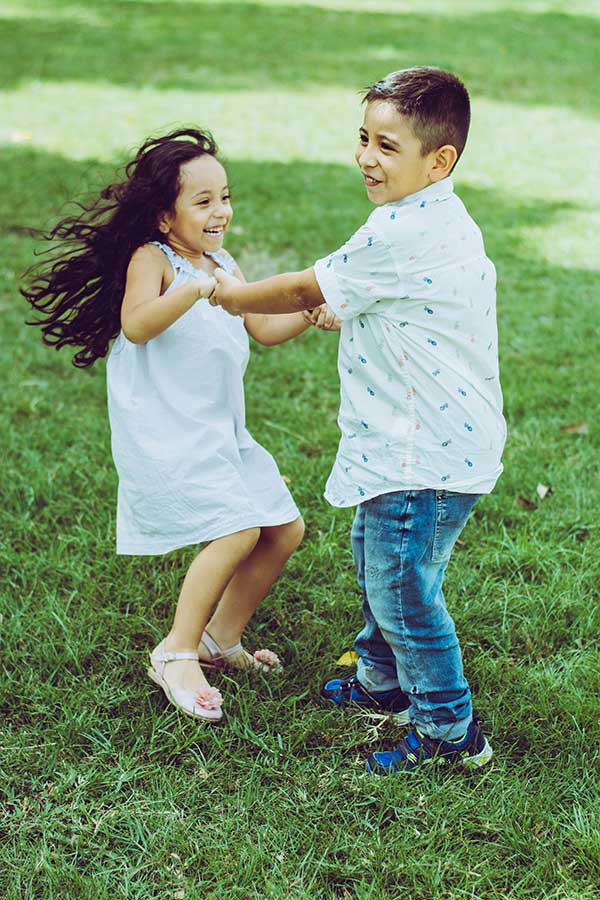 hermanos bailando sobre la hierba